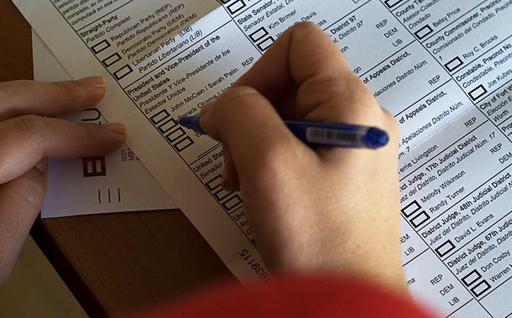 Close-up of hands using a felt-tip pen to mark ballot for 2008 U.S. presidential election