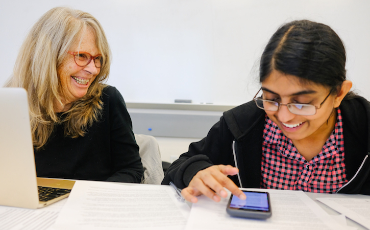 Professor and Student looking at cell phone and smiing